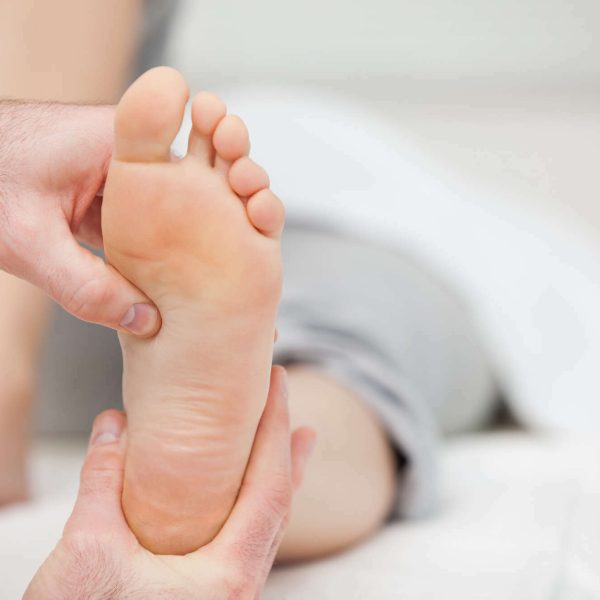 Doctor holding the foot of a woman in his office